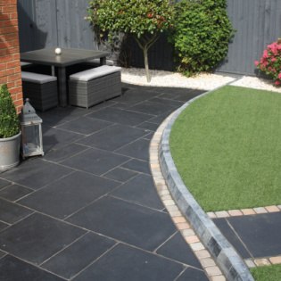 Luxury Garden With Artificial Grass and Natural Riven Patio Paving Slabs in Classicstone Carbon Black