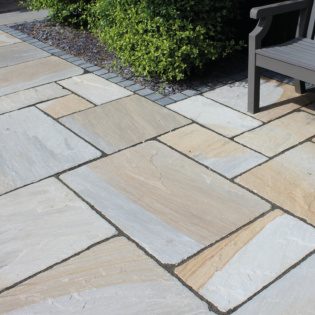 Cragstone Old York Grey & Buff Weathered Sandstone Patio Paving With Green Shrubs and Bench